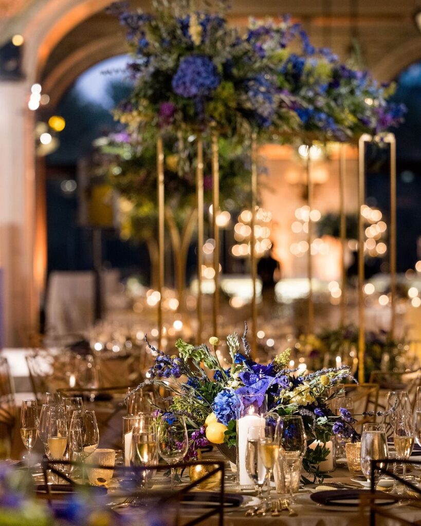 Close up of a tablescape with deep blue and purple flowers.