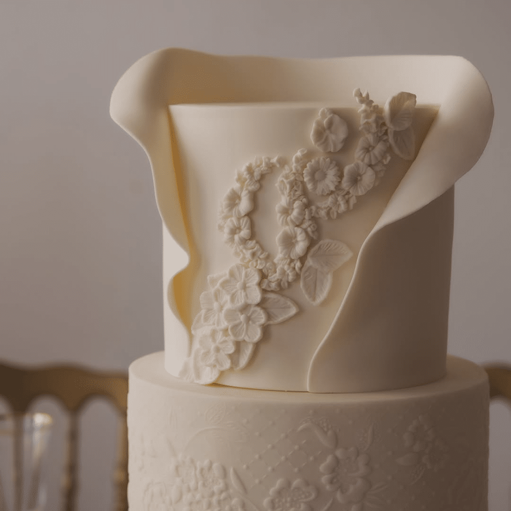 Cream colored two tiered wedding cake with florals.