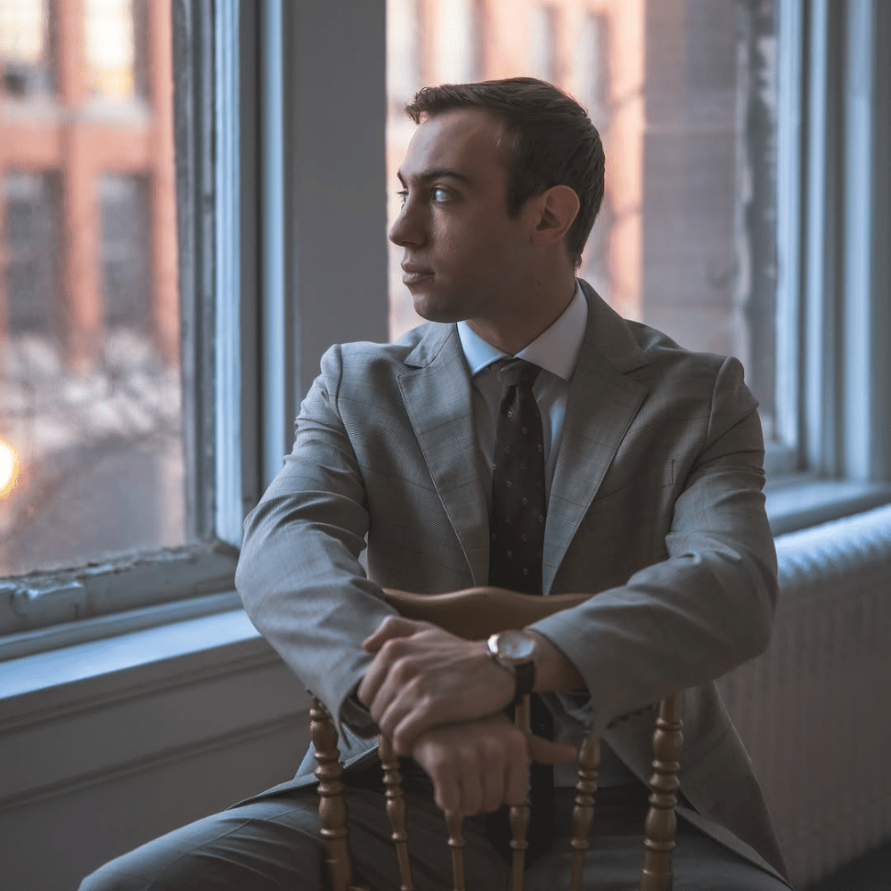 Groom sitting on gold chair.