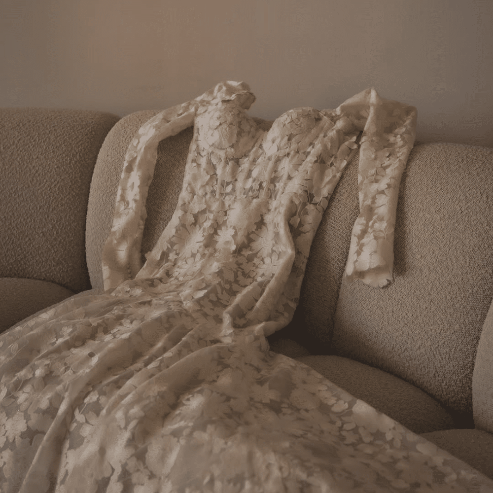 Wedding dress laying across a couch.