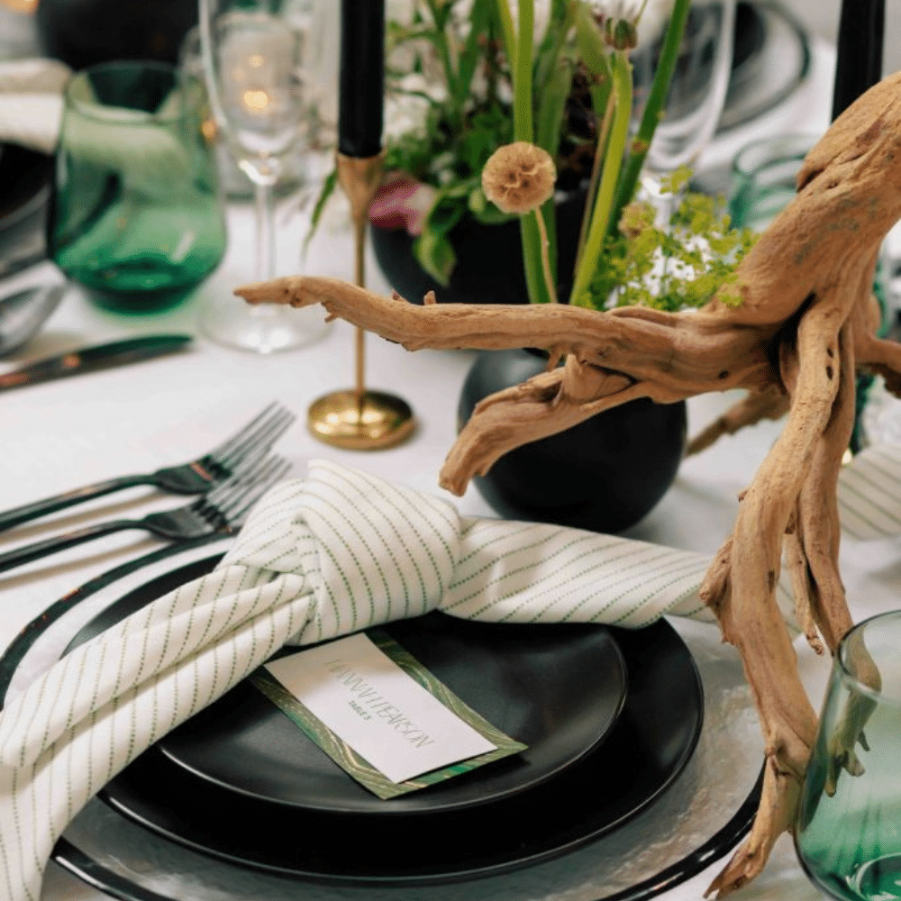 Wedding place setting with natural elements, sustainable event rentals, and black matte round plates.