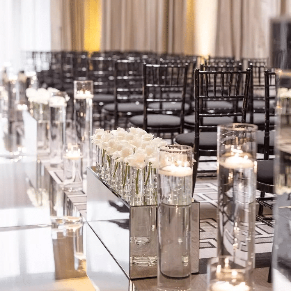 candlelit wedding ceremony aisle with mirrored aisle and white florals.