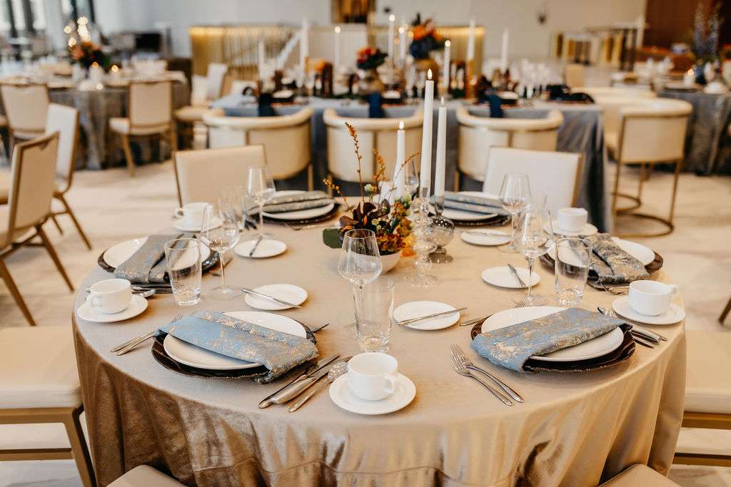 Brown copper chargers on champagne and blue linens